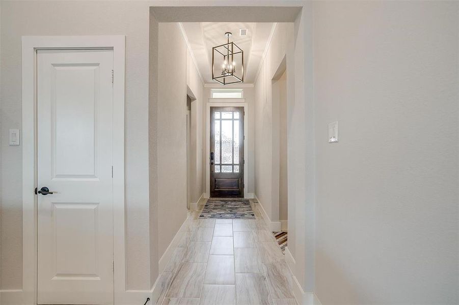 Entryway featuring chandelier and lovely wooden and glass front door.