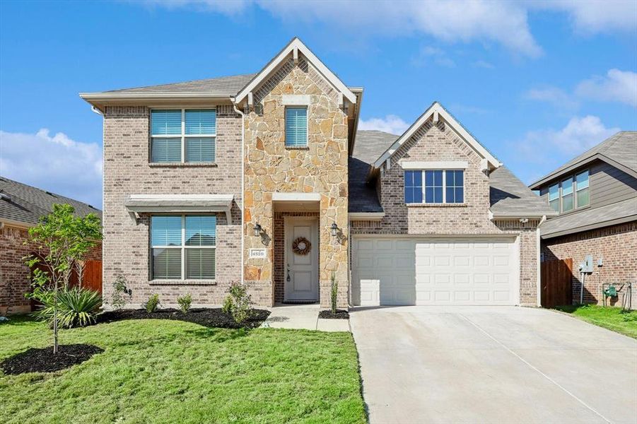 View of front of property with a garage and a front yard