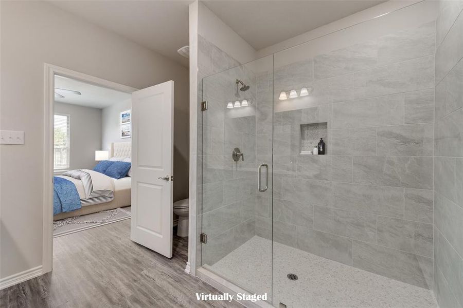 Bathroom featuring walk in shower, hardwood / wood-style flooring, and toilet