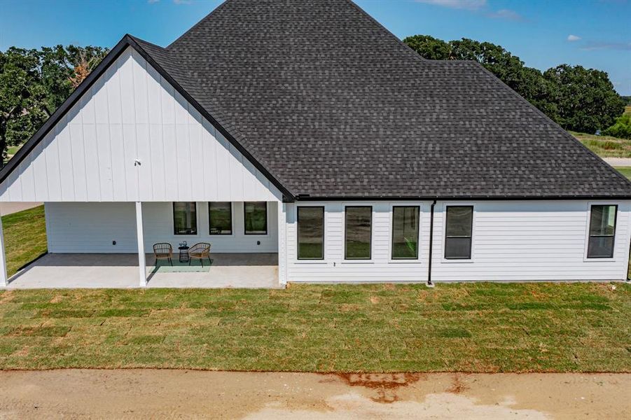 Rear view of property with a patio and a yard