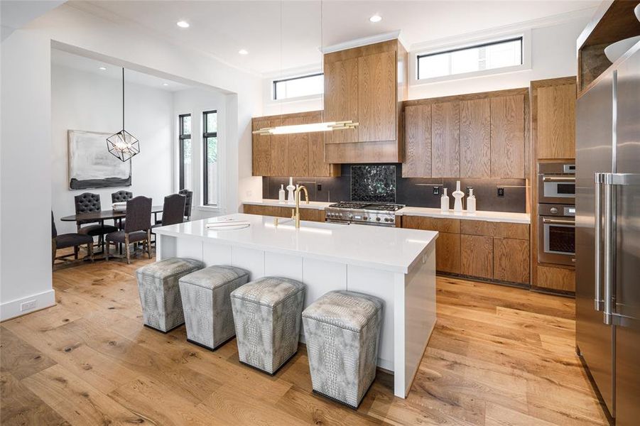 Center island with pull out breakfast bar, elegant hanging pendent and transom windows