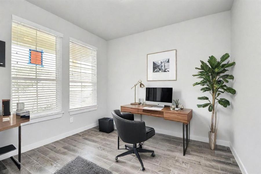 Experience the perfect blend of sophistication and warmth in this home office, boasting elegant wood-look tile flooring and flooded with natural light from expansive windows and French doors.