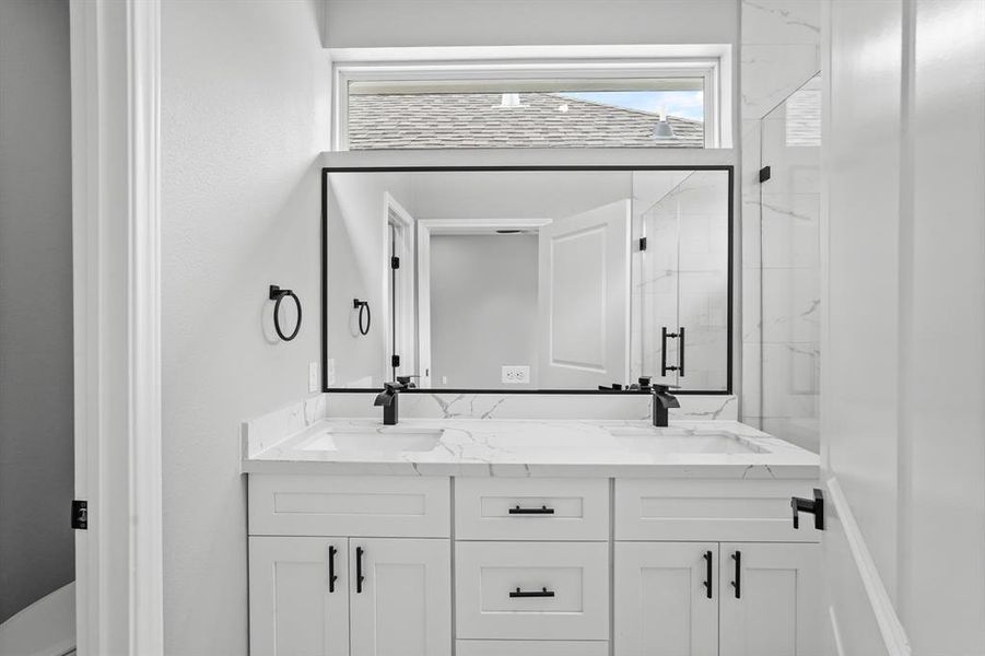 Secondary bathroom with double sinks.