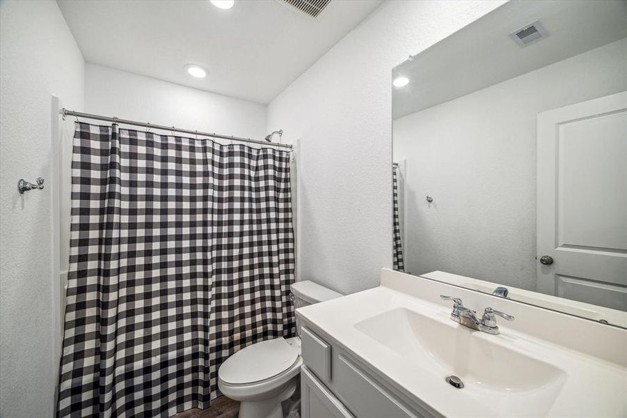 Well-appointed full bath featuring a combination tub and shower, sleek fixtures, and ample counter space, conveniently located to serve the upstairs bedrooms.