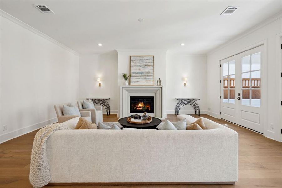 Family room features gas fireplace with beautiful cast stone surround and decorative sconces adjacent.