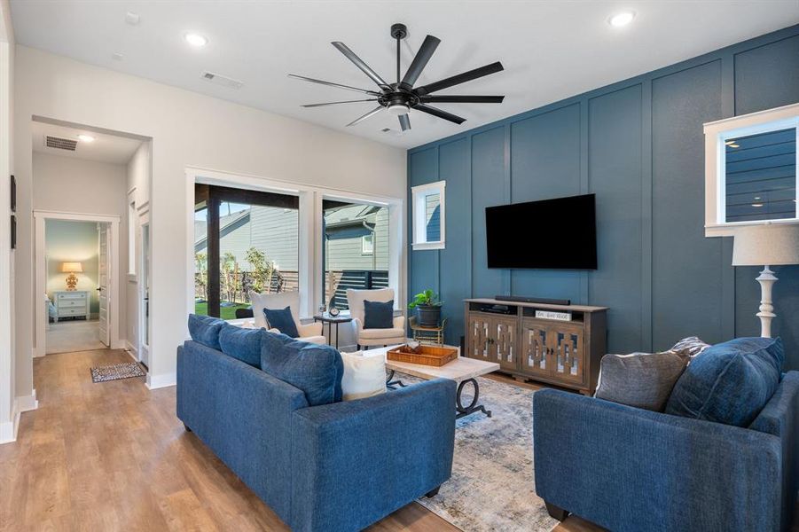 Cozy family room with feature wall, 2 large picture windows, and an upgraded ceiling fan. All the windows on the first floor have been trimmed out.