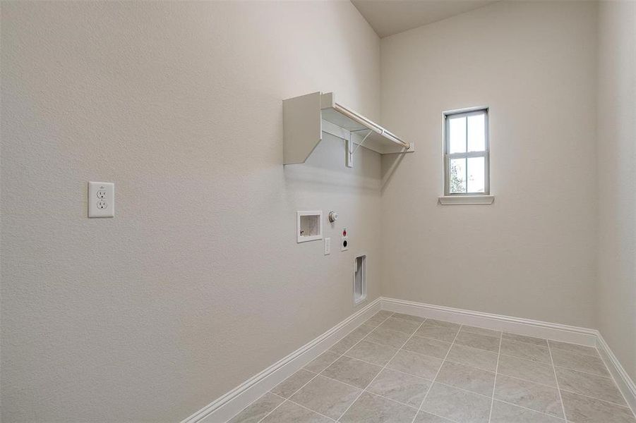 Laundry room featuring gas dryer hookup, light tile patterned flooring, hookup for an electric dryer, and hookup for a washing machine