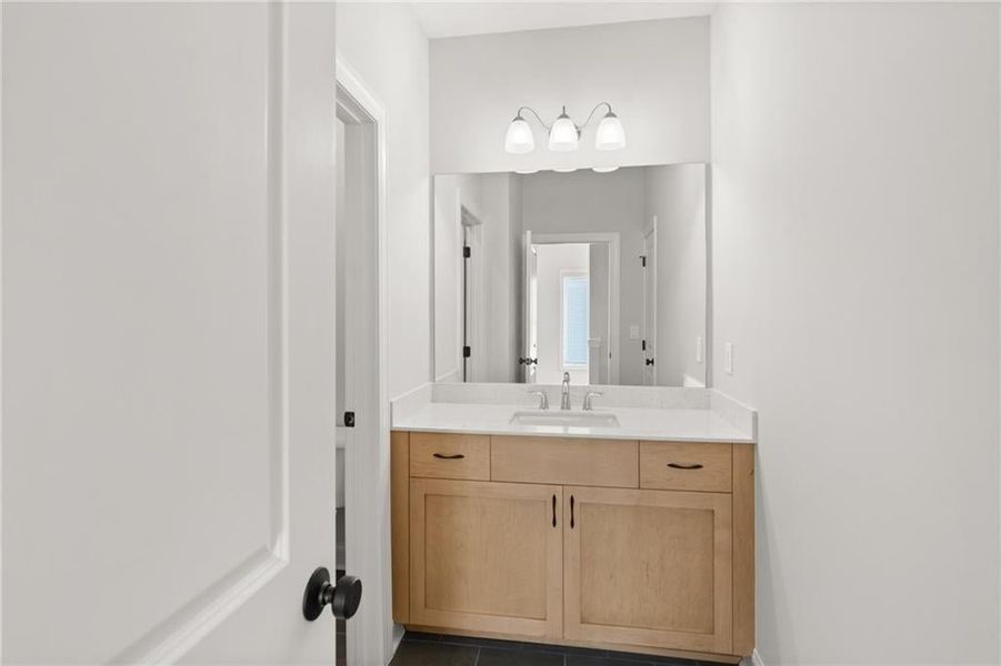 A shared bathroom serves the secondary bedrooms, featuring modern amenities and stylish finishes. NOT actual home. Photos of previously built Grayton floorplan.