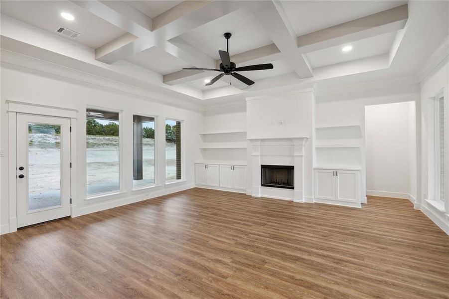 Unfurnished living room with hardwood / wood-style floors, coffered ceiling, and ceiling fan