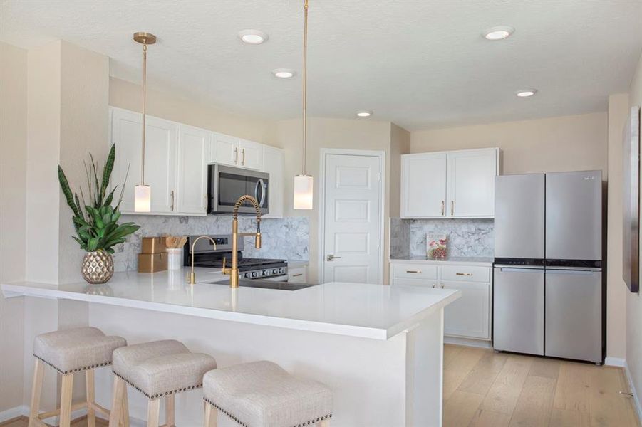 This spacious kitchen features high ceilings, stained wood cabinets, silestone countertops, SS appliances, modern tile backsplash, recessed lighting, extended breakfast bar to countertop, and a pantry all overlooking your huge family room.