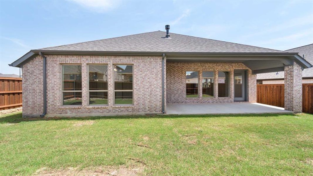 Rear view of property with a yard and a patio area