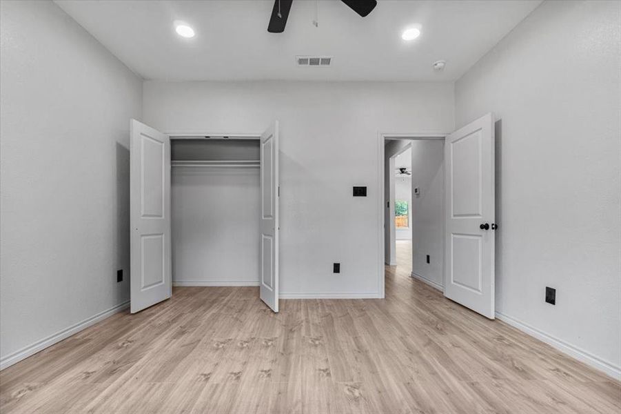 Unfurnished bedroom with light hardwood / wood-style floors, a closet, and ceiling fan