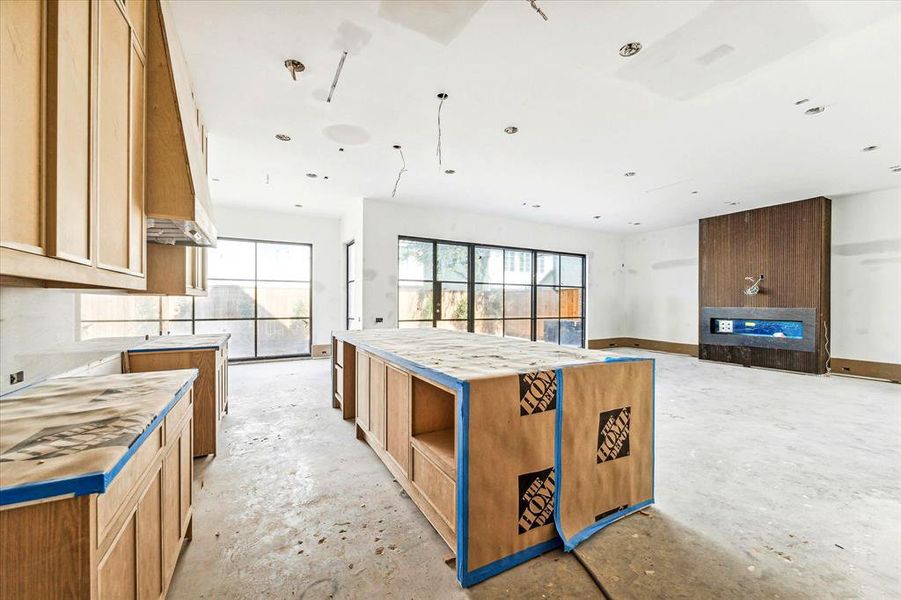 [Kitchen/Family/Breakfast Room] Floor to ceiling doors and windows for the ultimate indoor/outdoor living. Complemented by calming tones and a mix of textures such as wood and matte finishes, ensuring every space feels balanced and inviting. 60" linear fireplace.