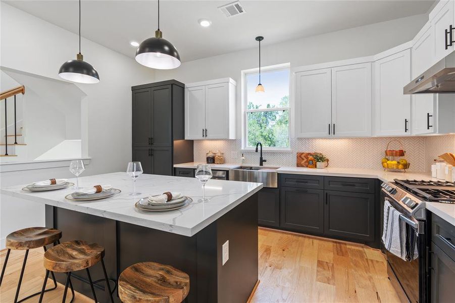 The kitchen boasts stunning two-tone custom cabinets that exude timeless elegance, while an oversized pantry to the left offers abundant storage, striking a perfect balance between aesthetics and practicality.