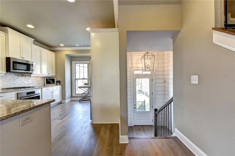 Kitchen with stainless steel appliances, wood-type flooring, backsplash, stone countertops,  cabinetry  Photos NOT OF ACTUAL Home but for representation Purposes only. Home is UNDER Construction- Photos are of a previously built Freemont plan by The Prov