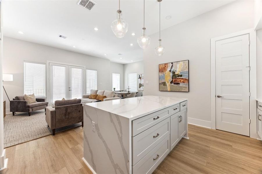 Kitchen island with waterfall quartz counter has tons of storage and oversized drawers for pots and pans.