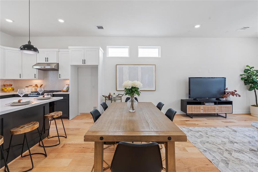 The spacious dining area effortlessly accommodates large gatherings, highlighting the home's generous proportions while providing an inviting setting for memorable feasts and celebrations.