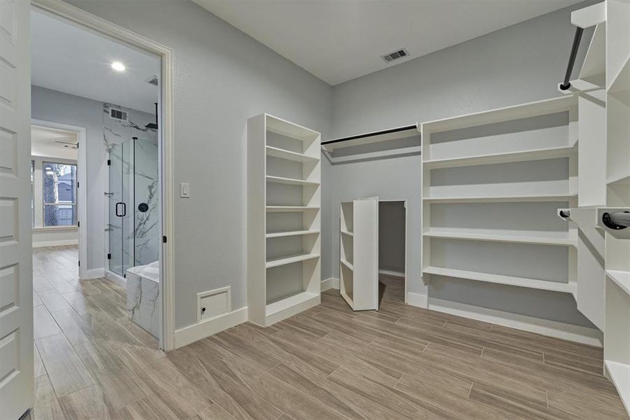 Access to the primary closet from the bath. A secret area behind the built in shelf provides a hidden storage space!