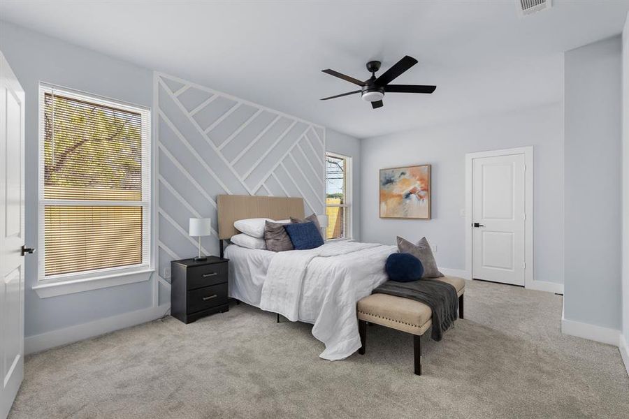 Carpeted bedroom featuring ceiling fan