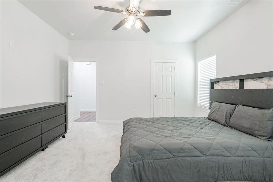 Carpeted bedroom with ceiling fan