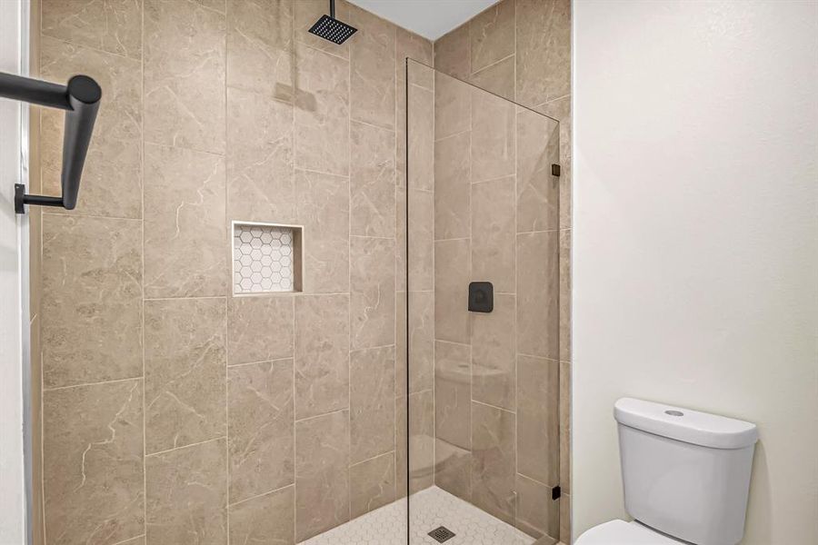 Guest bath also features a seamless glass panel and tile inset.