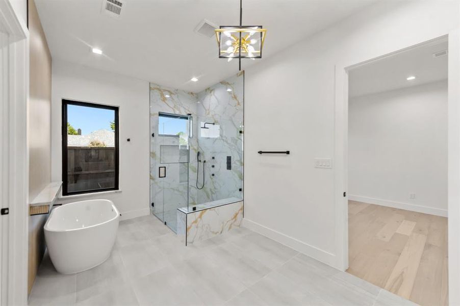 Master Bathroom featuring an inviting chandelier, shower with separate bathtub, and hardwood / wood-style flooring