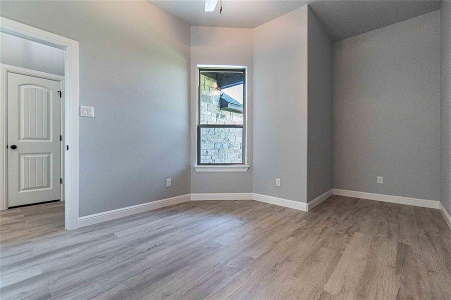 Unfurnished room featuring light wood-type flooring and ceiling fan