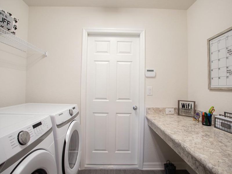 Laundry room with convenient drop zone at the garage entry - Raychel home plan by Highland Homes