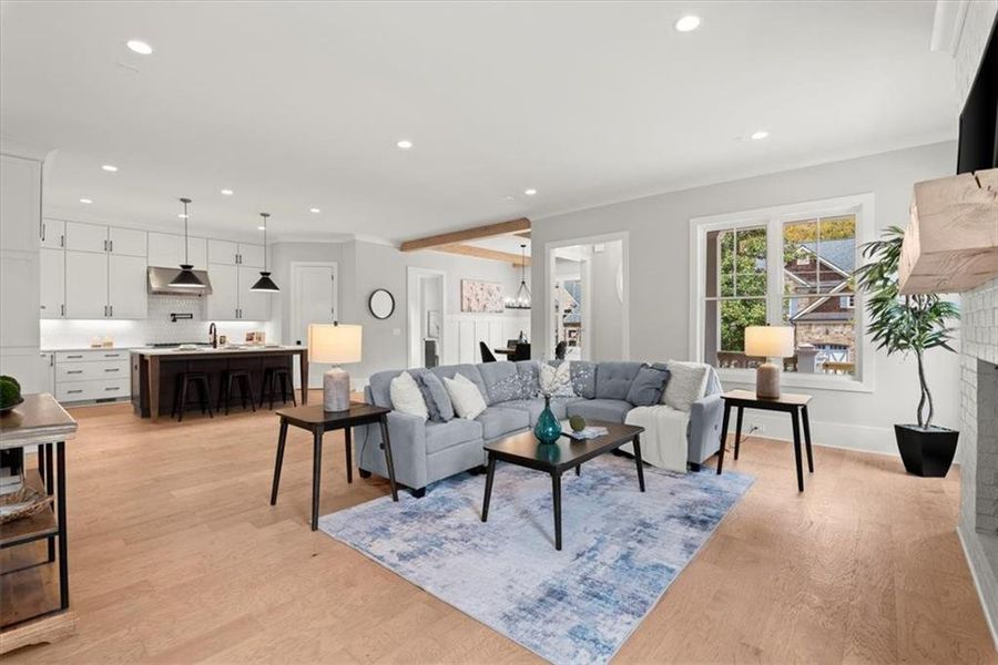 Living room featuring light hardwood / wood-style floors, ornamental molding, and a fireplace