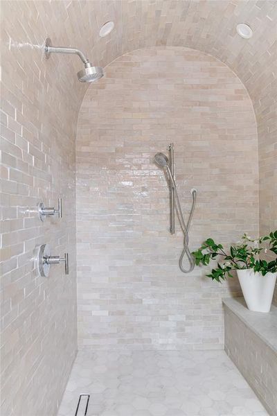 Bathroom featuring vaulted ceiling and tiled shower