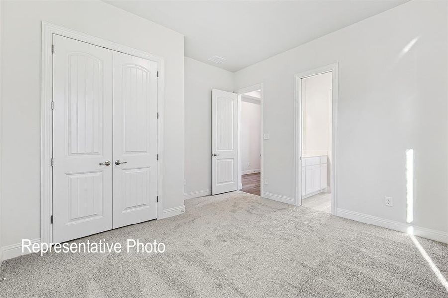 Unfurnished bedroom with a closet and light carpet