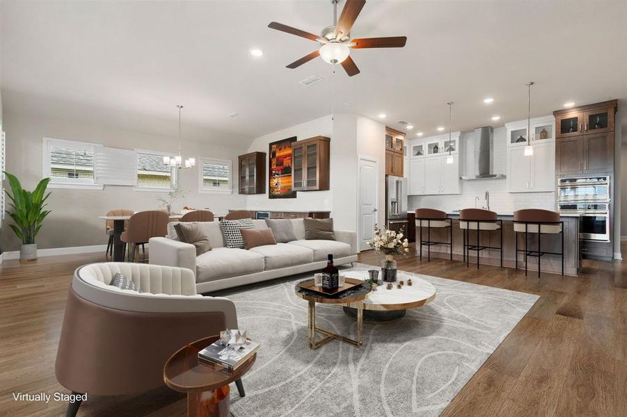 Gather the family and guests together in your lovely living room! Featuring high ceilings, recessed lighting, dark stained ceiling fan, neutral paint, gorgeous wood floors and large windows that provide plenty of natural lighting throughout the day.