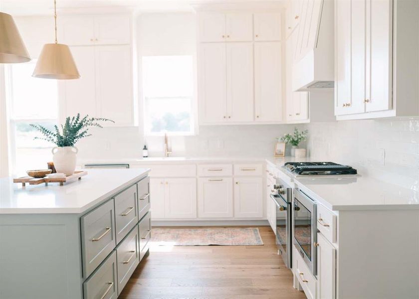 Kitchen with a healthy amount of sunlight, sink, tasteful backsplash, and light hardwood / wood-style flooring