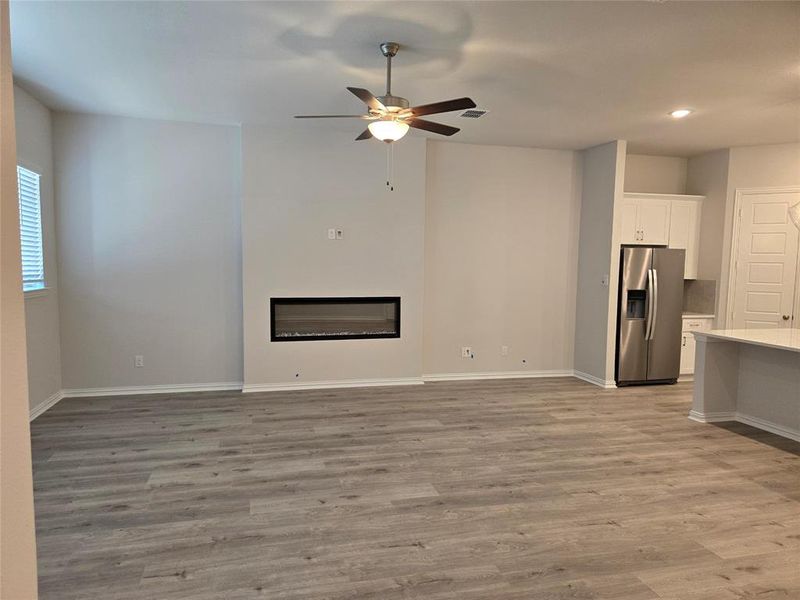 Unfurnished living room featuring light hardwood / wood-style flooring and ceiling fan