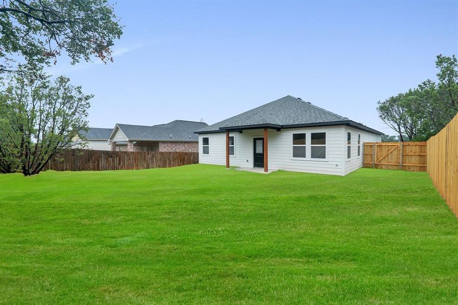 Rear view of property with a lawn