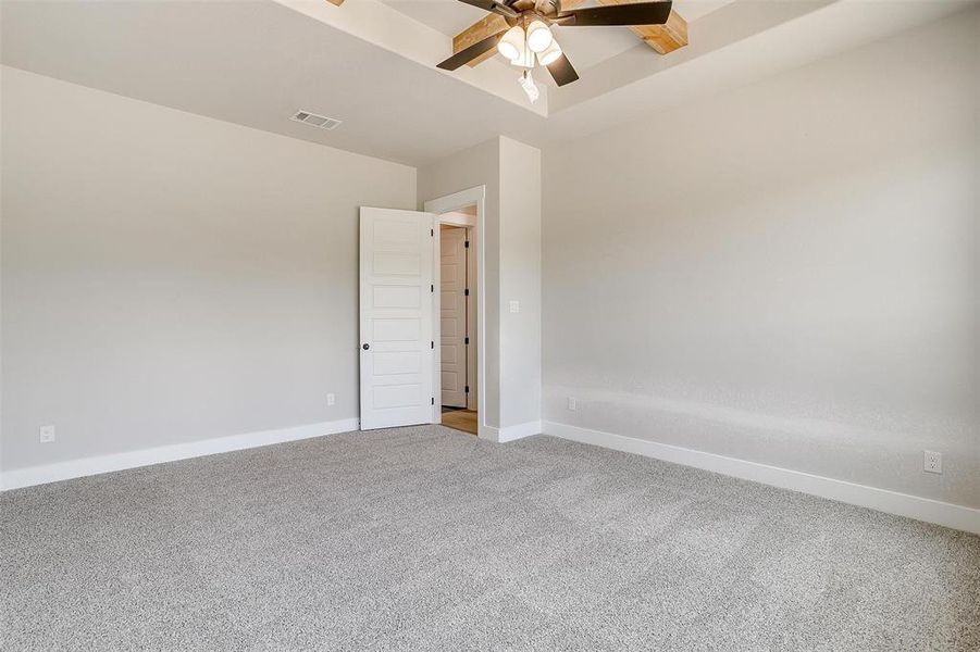 Empty room with ceiling fan and carpet floors