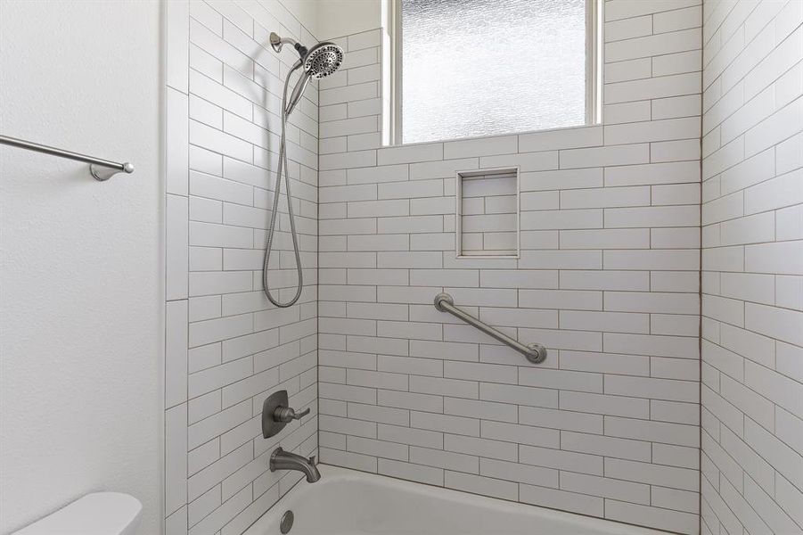 Bathroom featuring toilet and tiled shower / bath