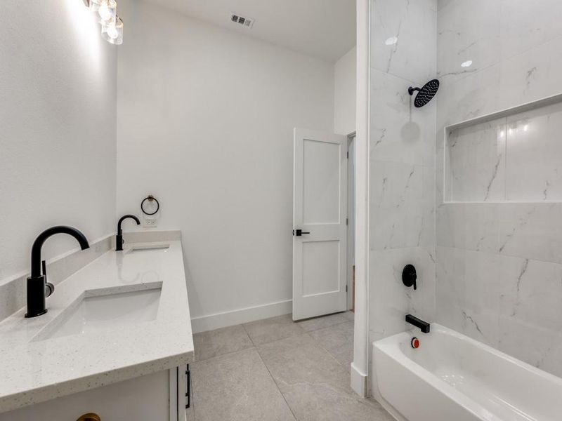 Bathroom with tiled shower / bath, vanity, and tile patterned floors