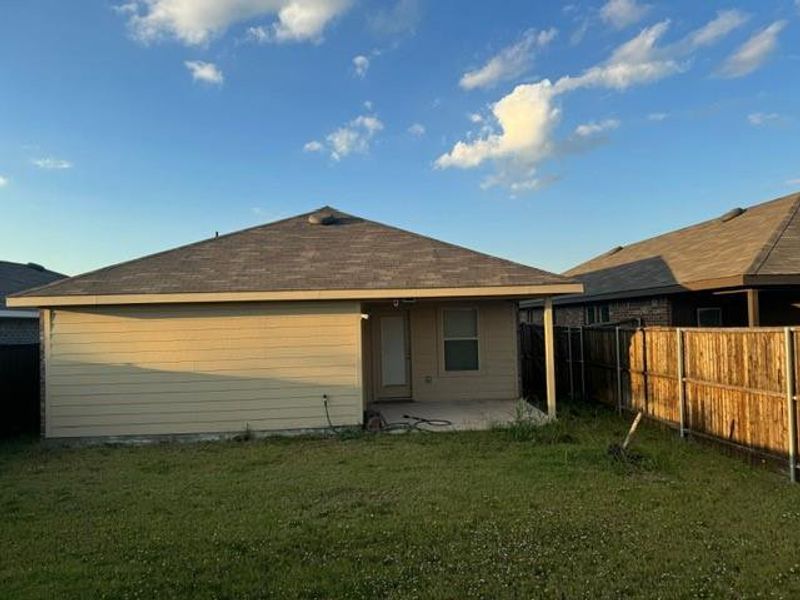 Back of property featuring a lawn and a patio area