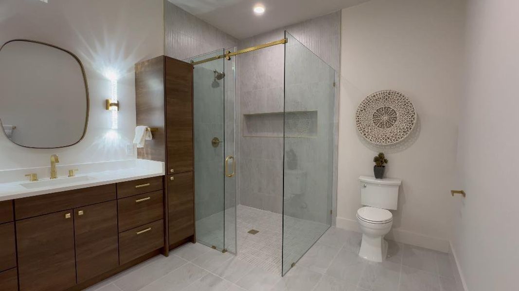 Bathroom featuring vanity, toilet, a shower with door, and tile patterned flooring