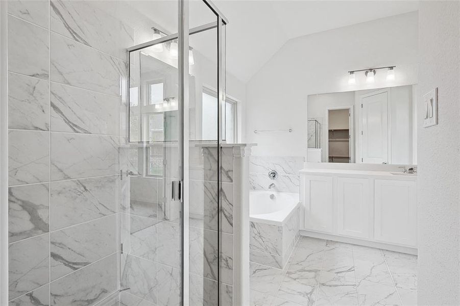 Bathroom featuring vanity, tile patterned flooring, vaulted ceiling, and separate shower and tub