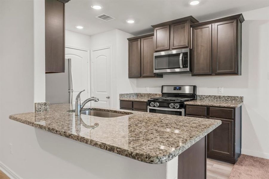 THE GOURMET KITCHEN IS THE HEART OF THIS FINE HOME  and boasts exotic granite countertops, wood-look vinyl plank flooring, stainless appliances, and breakfast bar seating.