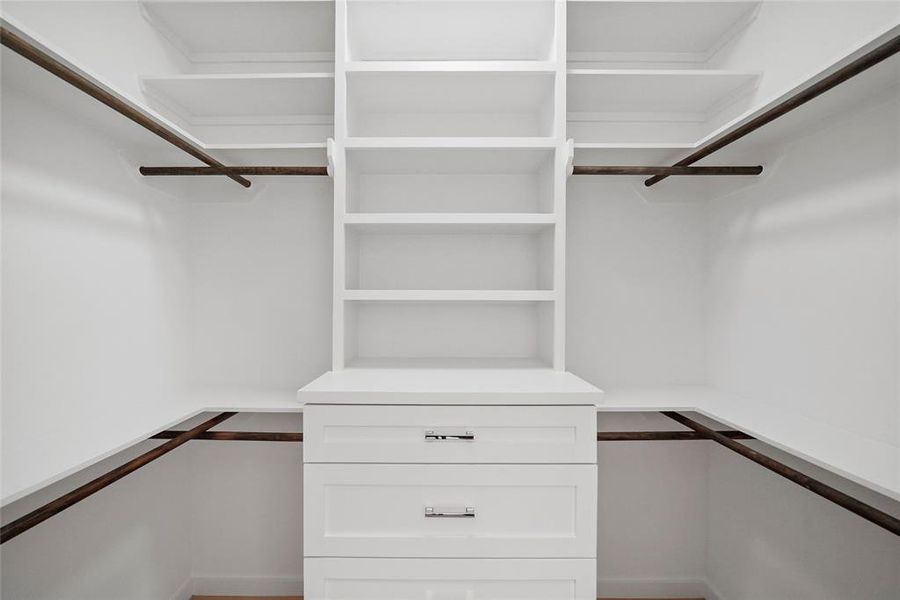 Spacious walk-in closet with ample shelving and hanging space.