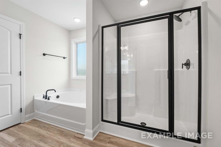 Bathroom with wood-type flooring and separate shower and tub