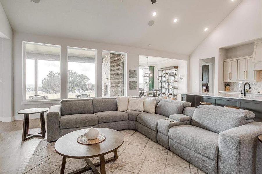 Living room featuring a chandelier, high vaulted ceiling, and sink