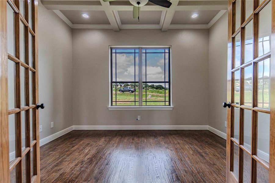 Spare room featuring beam ceiling, coffered ceiling, french doors, and dark hardwood / wood-style floors