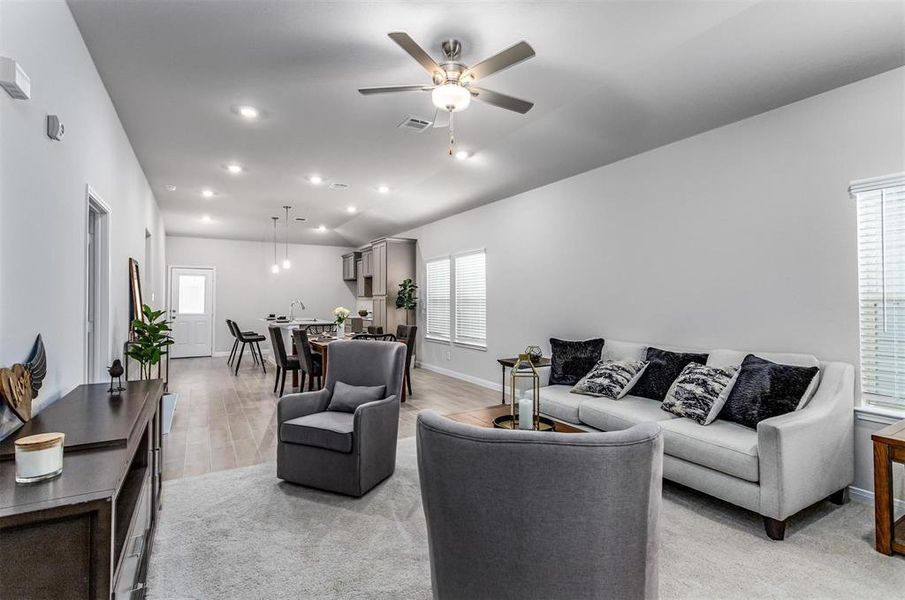 The open living area seamlessly integrates the living, dining, and kitchen spaces, creating an ideal environment for family gatherings or entertaining guests. With high ceilings and abundant natural light, the room feels bright and spacious, exuding both warmth and elegance. **This image is from another Saratoga Home - Mockingbird floorplan.**