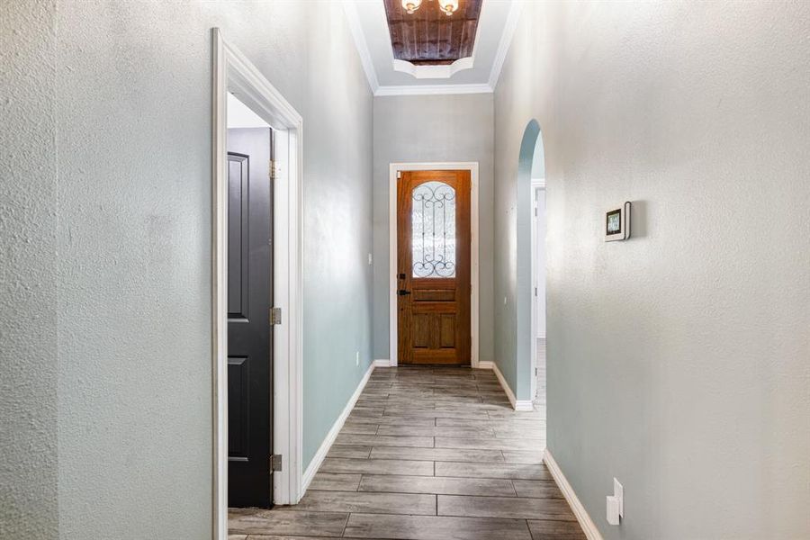 Doorway to outside featuring wood-type flooring and ornamental molding