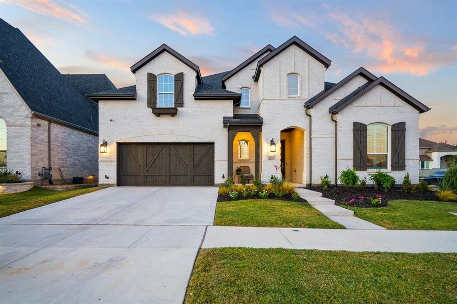 French provincial home featuring a yard and a garage