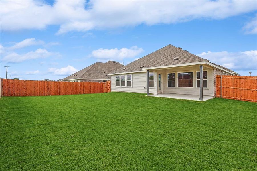 Back of property with a lawn and a patio